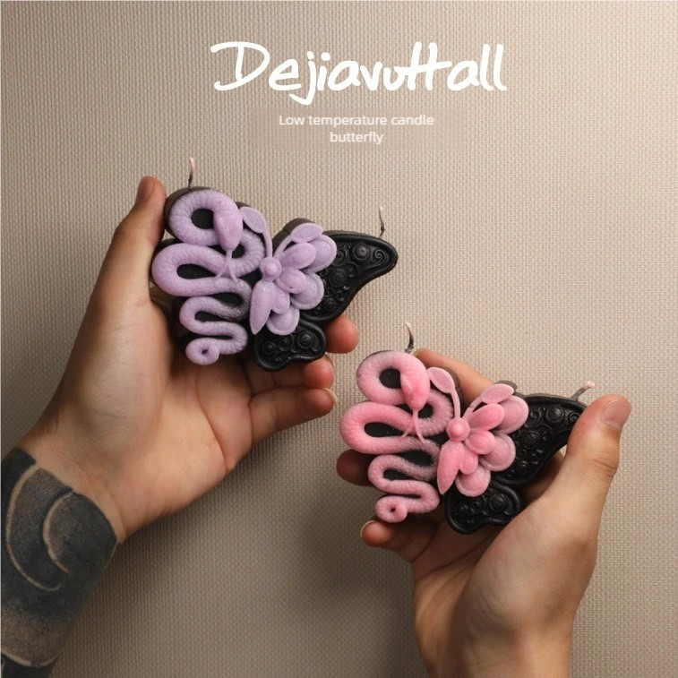 Butterfly snake drip wax candle lit with a soft and warm glow